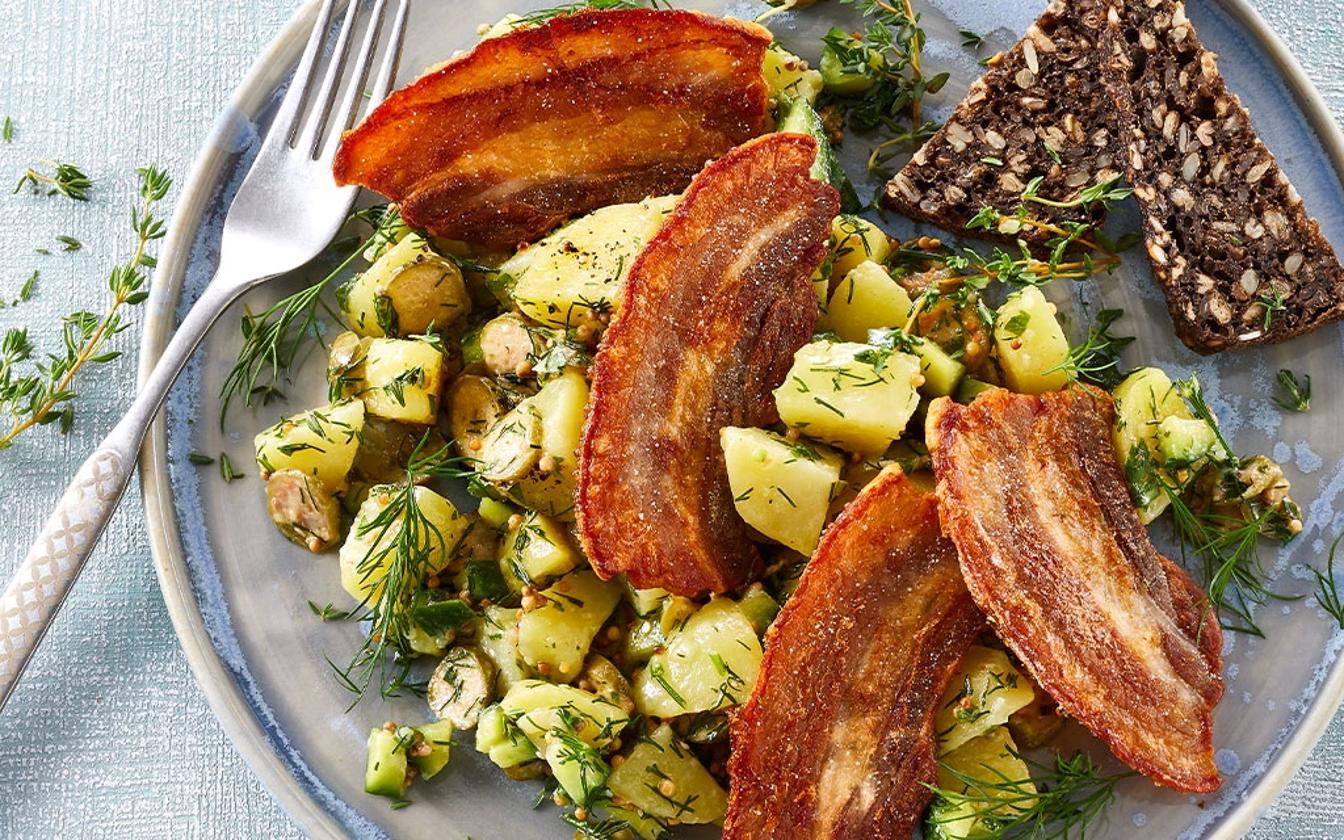 Stegt flæsk i skiver med kartoffelsalat med løvstikke og sennep